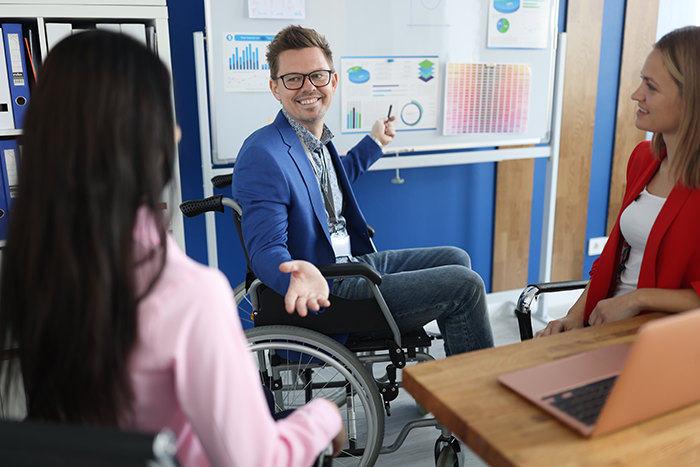 Businessman in wheelchair holds business conference in office